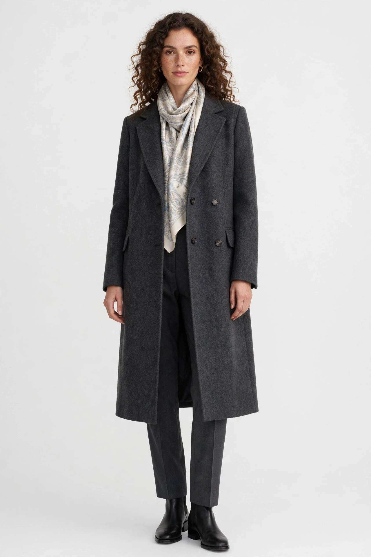 Woman wearing a charcoal grey coat with a silk scarf