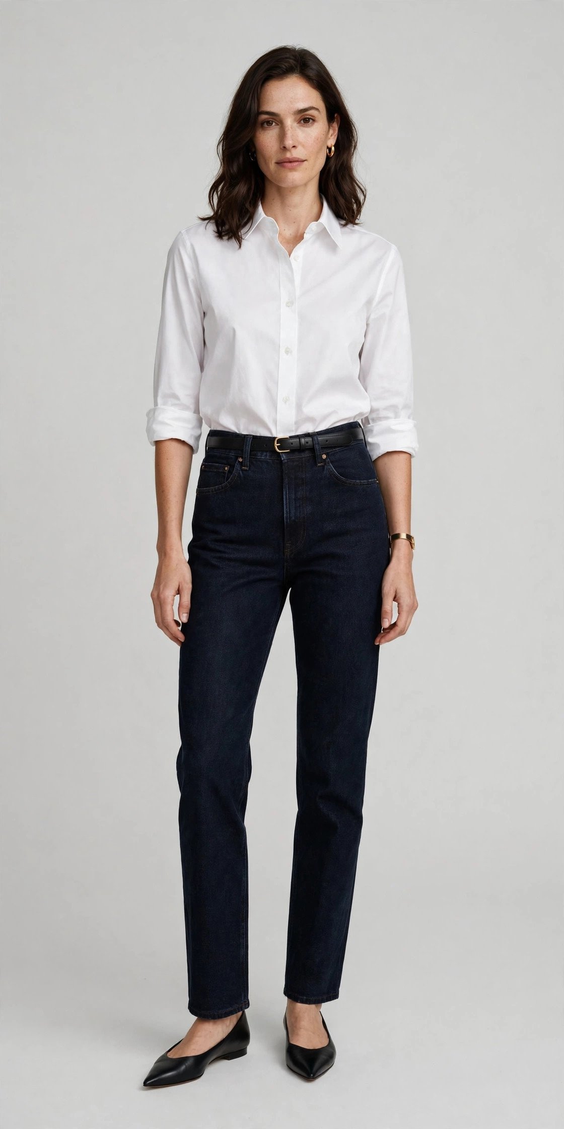 Woman in straight-leg dark jeans and a crisp white shirt at the office