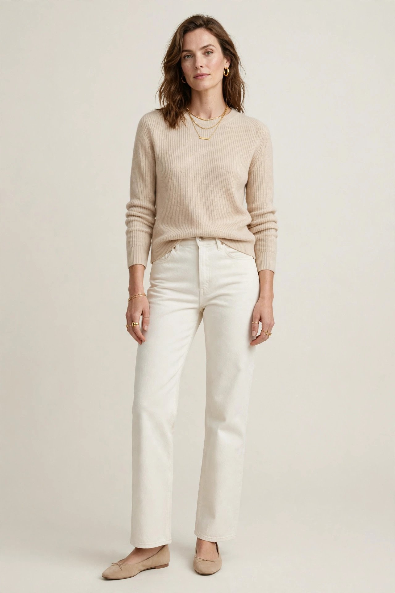 Woman in ecru off-white jeans with a beige knit sweater