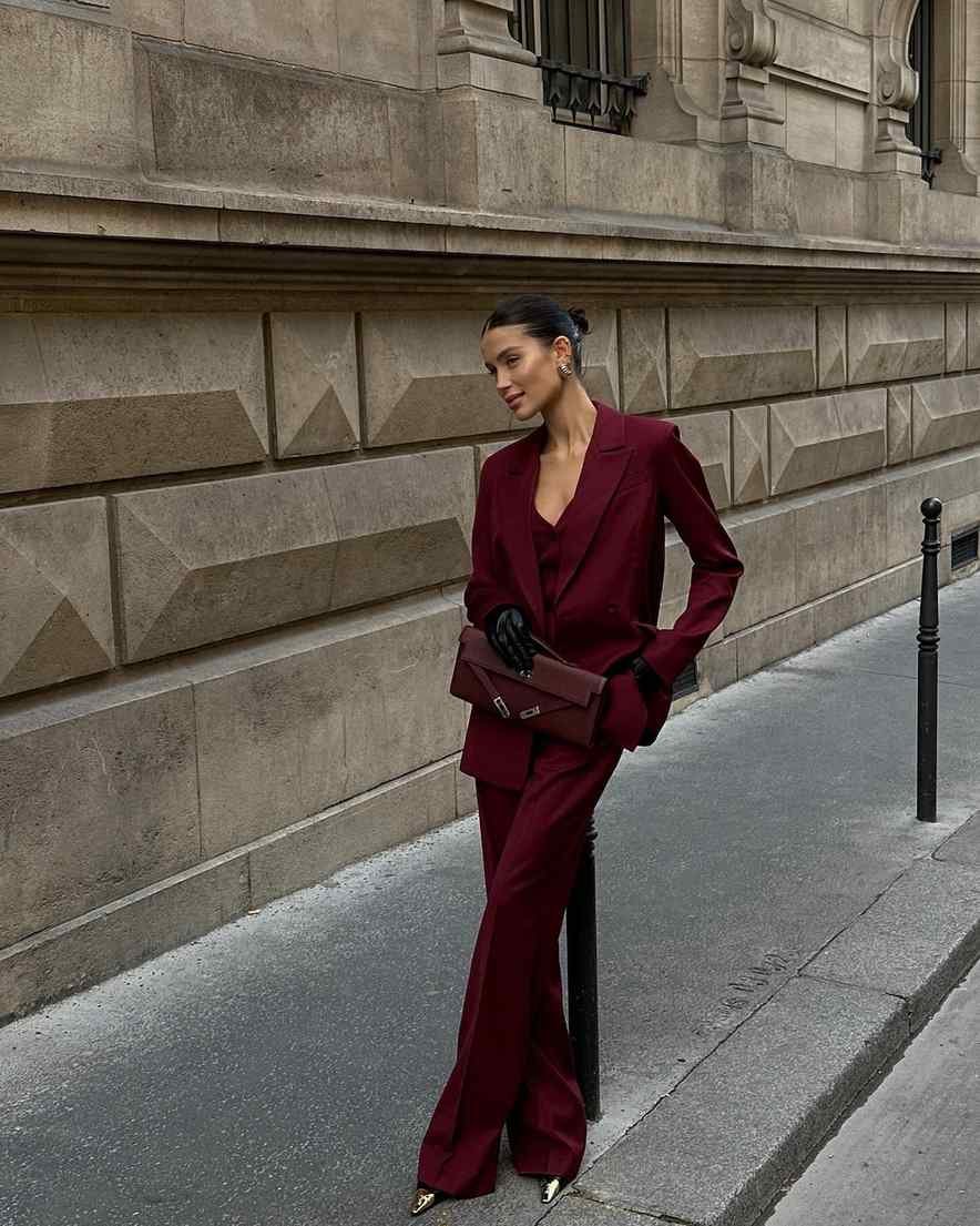 Woman in burgundy trouser suit statement work travel outfit