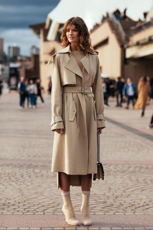 Woman in trench coat over business casual work travel outfit