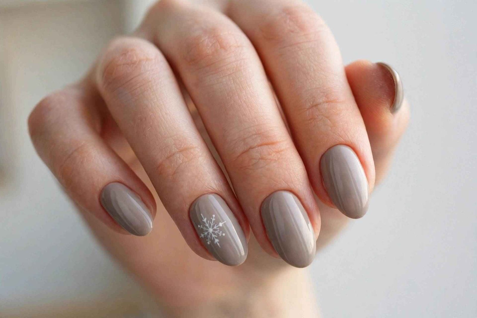 Taupe nails with delicate white snowflake art
