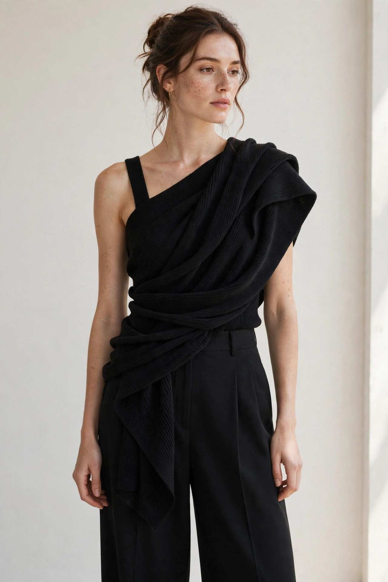 Woman in a one-shoulder knit top with wide-leg pants