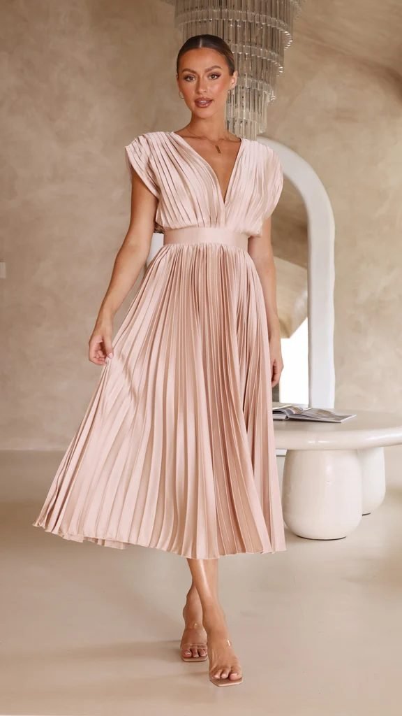 Woman in a blush pleated midi dress