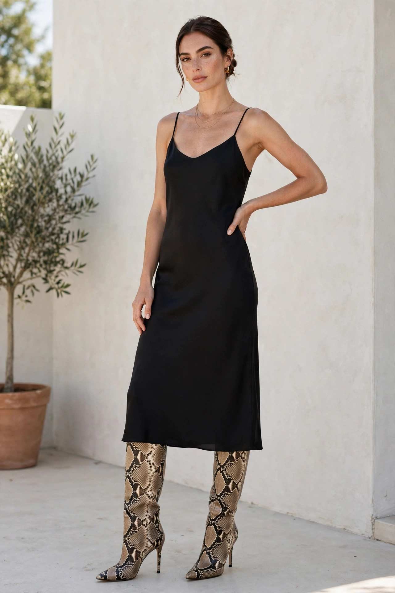 Woman in snakeskin boots with a black dress