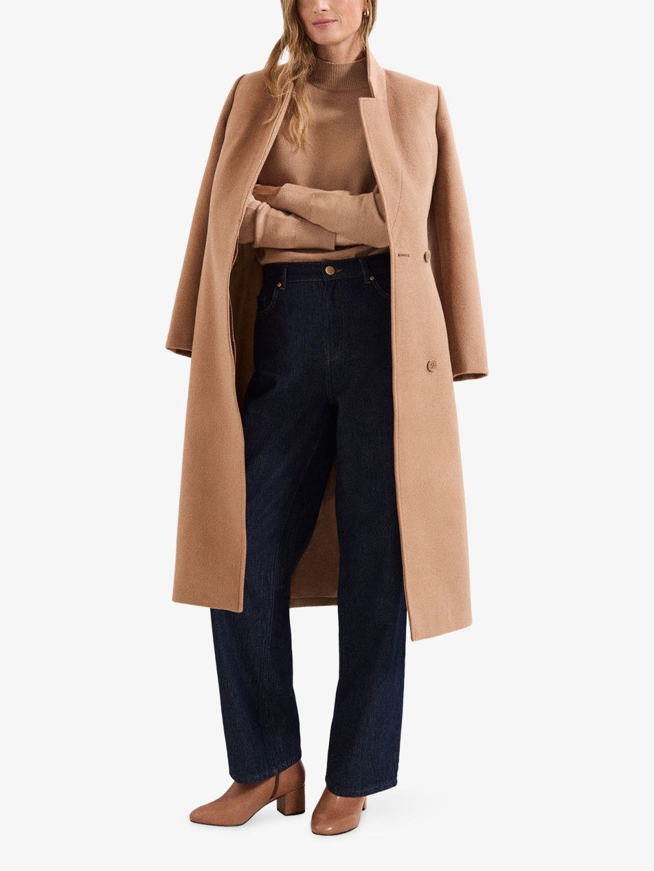 Woman in camel turtleneck sweater with jeans and ankle boots