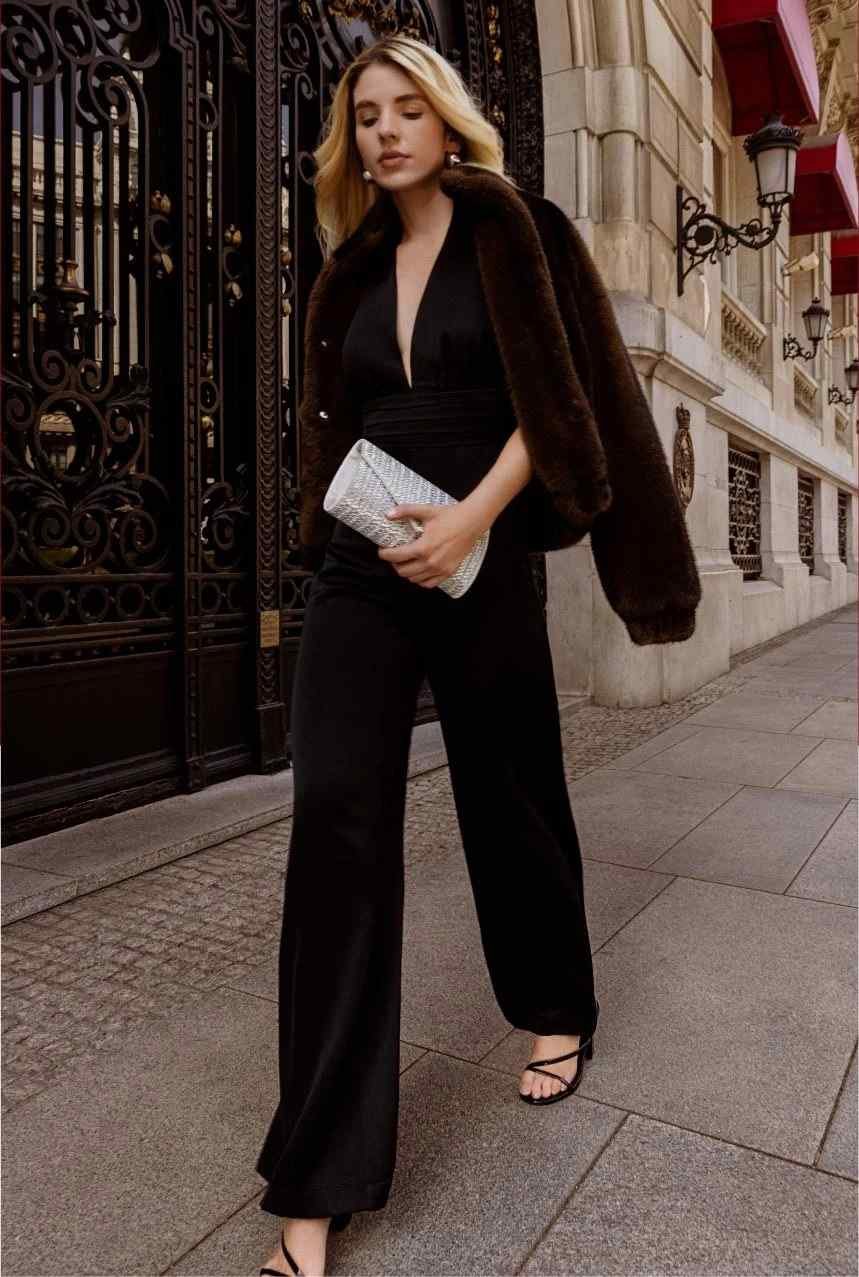 Woman in brown fur coat and black jumpsuit evening look