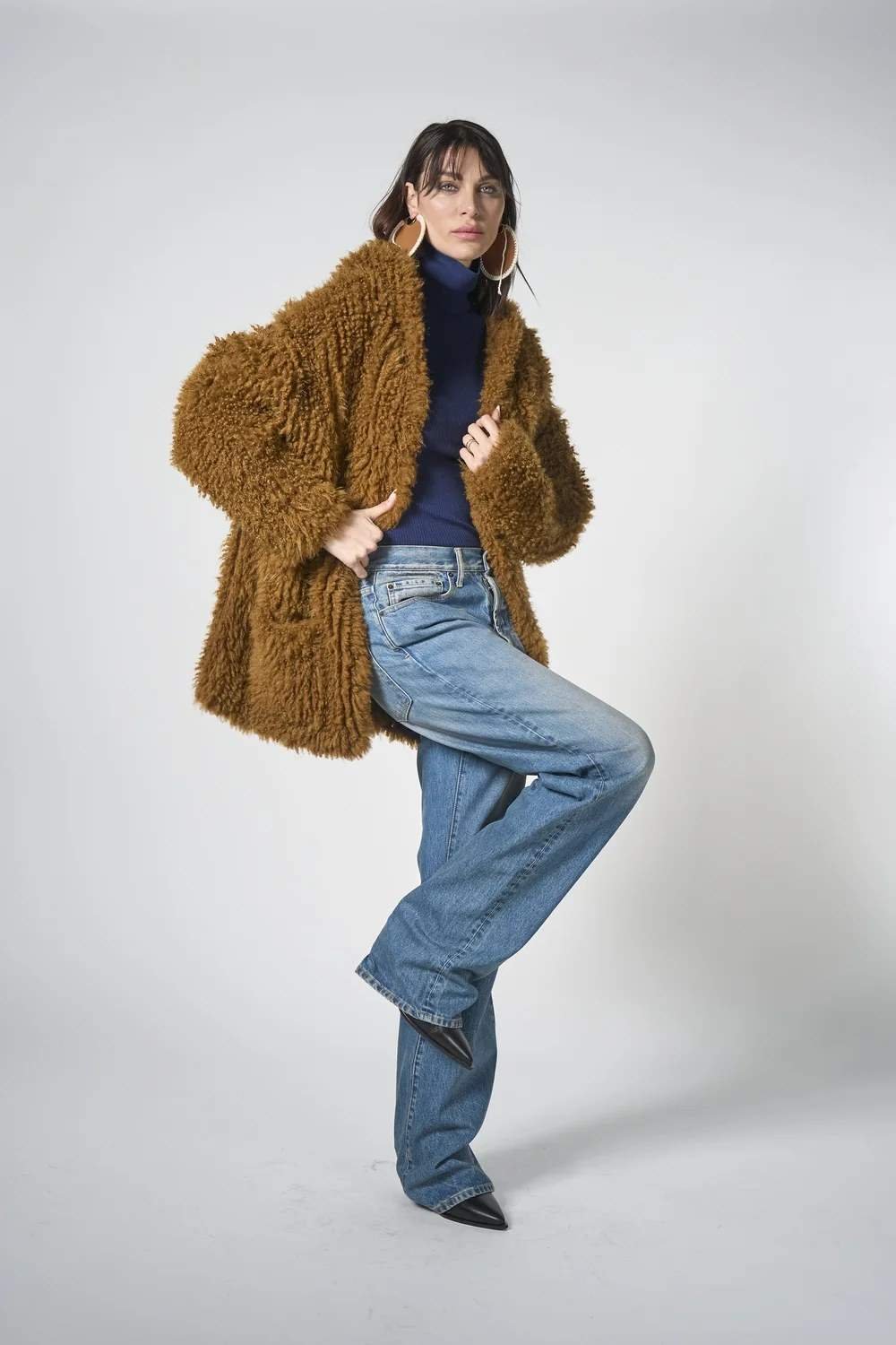 Woman in brown faux fur coat with turtleneck and wide leg jeans