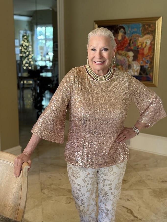 Woman over 40 in sequin top and tailored trousers