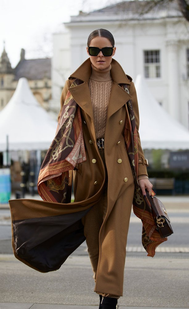 Woman in ivory turtleneck sweater with camel coat and silk scarf