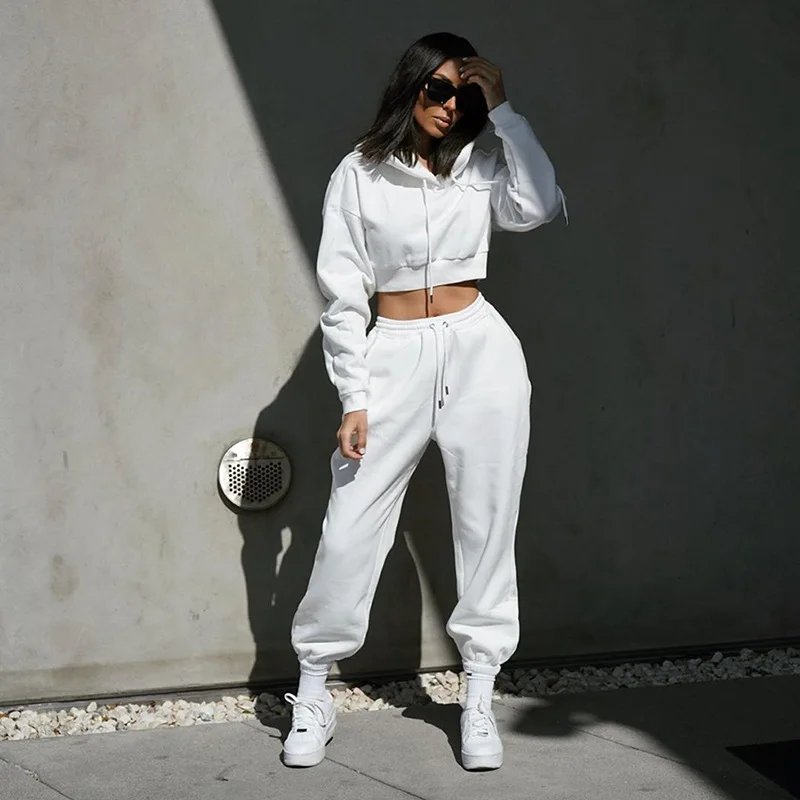 Woman in black trench coat with athleisure set and sneakers