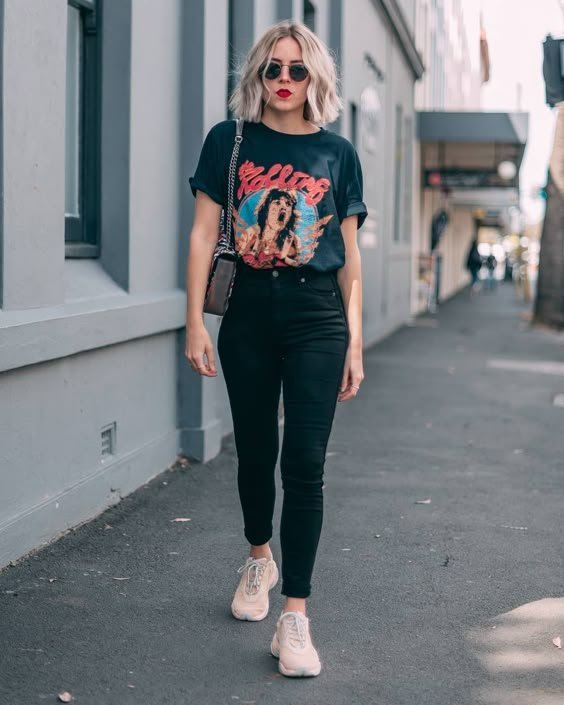 Woman in black trench coat with graphic tee and black jeans
