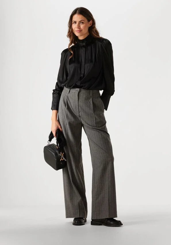 Woman in black trench coat with grey wide-leg trousers and heels
