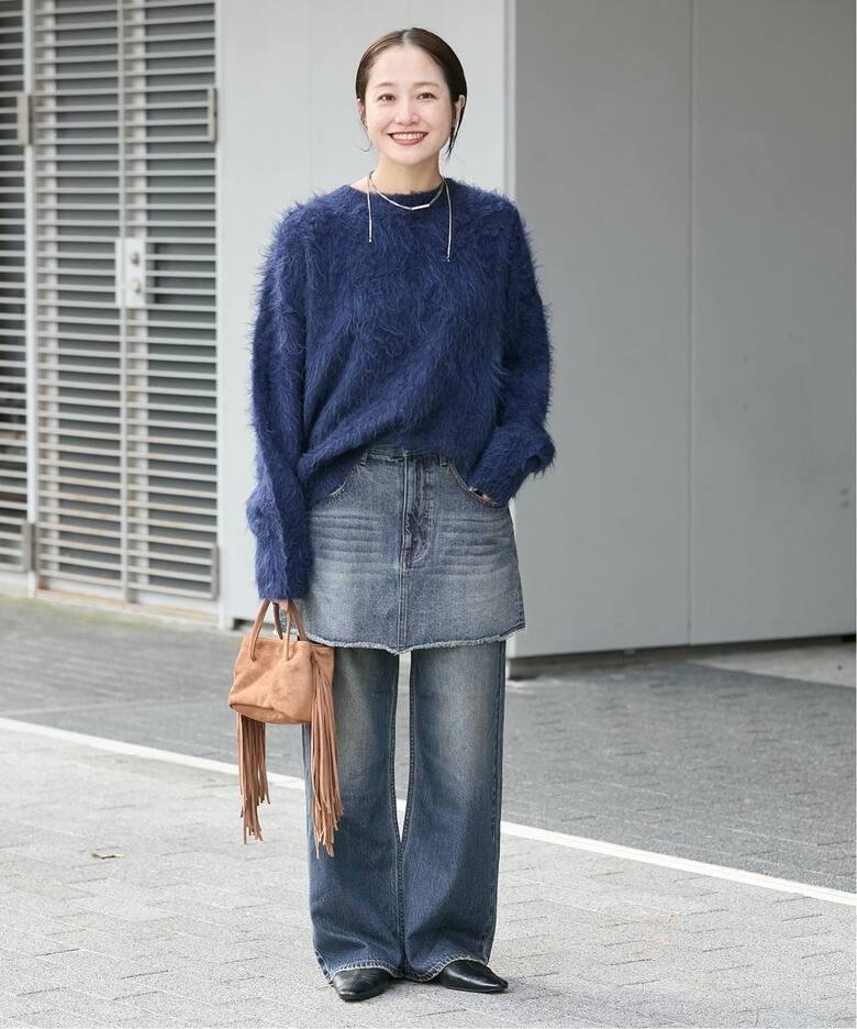 Mini skirt layered over skinny jeans