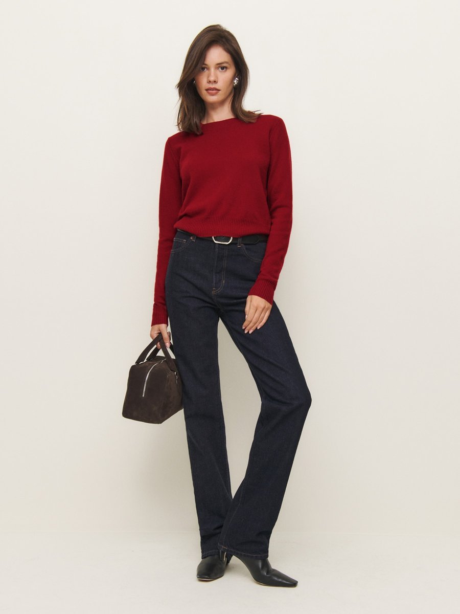 Woman in a red sweater with dark jeans, casual Christmas outfit