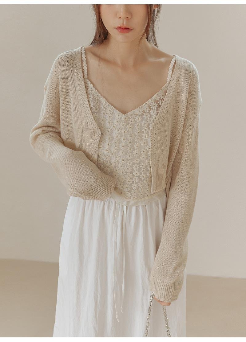Woman wearing a sparkly camisole with a black cardigan for evening