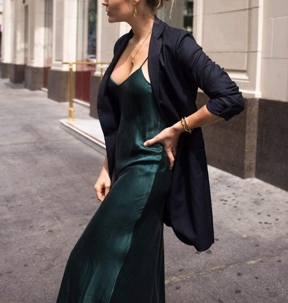 Woman in an emerald slip dress with an oversized blazer