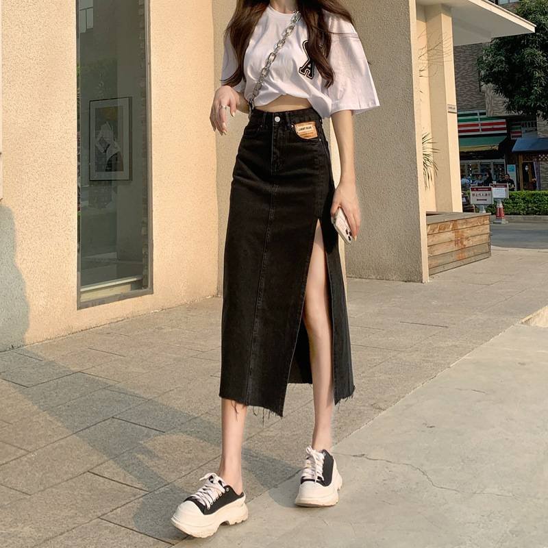 Woman in a cropped tee with a frayed denim midi skirt