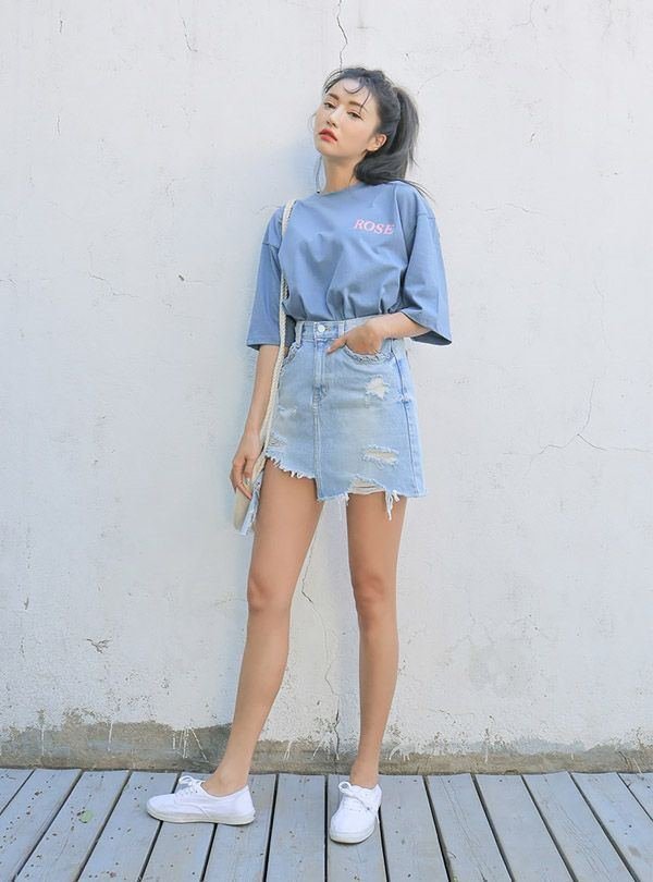 Woman wearing an oversized tee with a distressed denim mini skirt