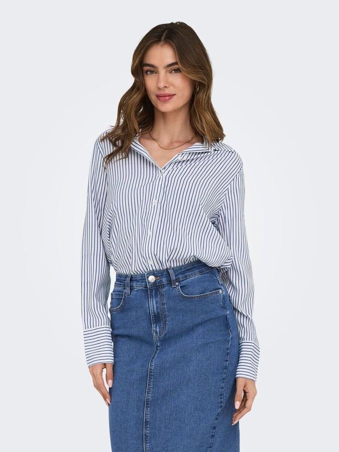 Woman in a striped long-sleeve top tucked into a denim midi skirt