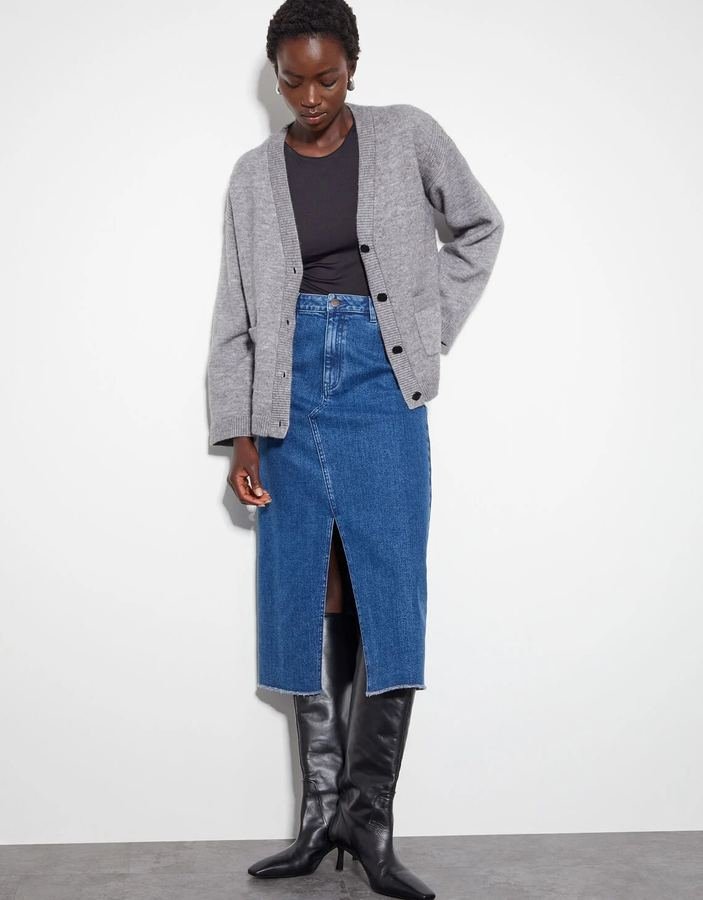 Woman wearing a cozy cardigan over a button-front denim midi skirt