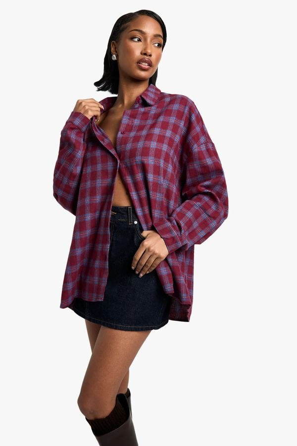 Woman in a flannel shirt with a denim midi skirt and boots
