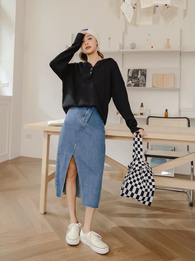 Woman in a henley top with a denim midi skirt carrying a tote bag