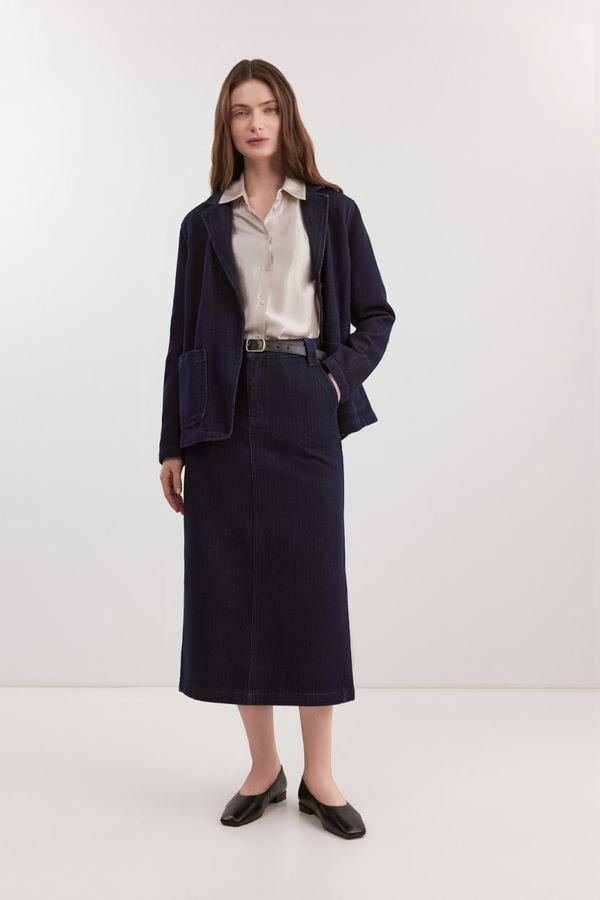 Woman in a structured blazer with a black denim midi skirt