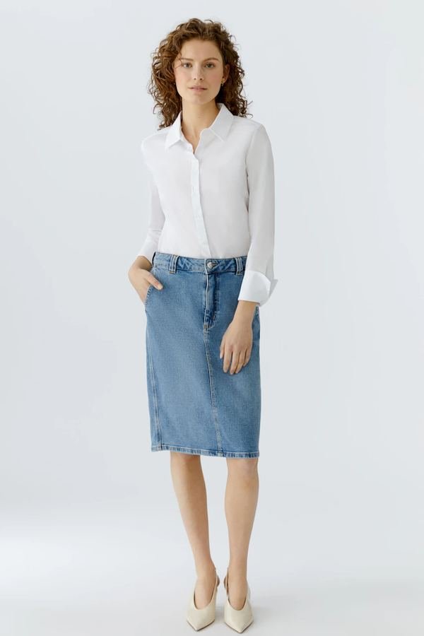 Woman in a crisp poplin shirt with a knee-length denim skirt