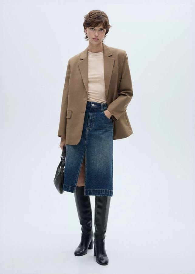 Woman in a camel blazer with a dark denim midi skirt