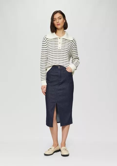 Woman in a knit polo with a denim midi skirt and loafers