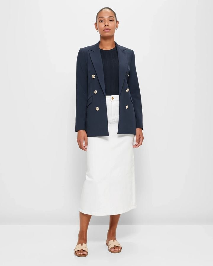 Woman in a navy blazer with a white denim midi skirt