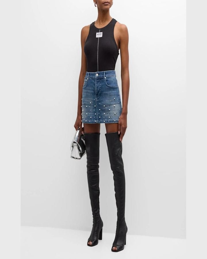 Woman in a fitted denim mini skirt with heeled boots