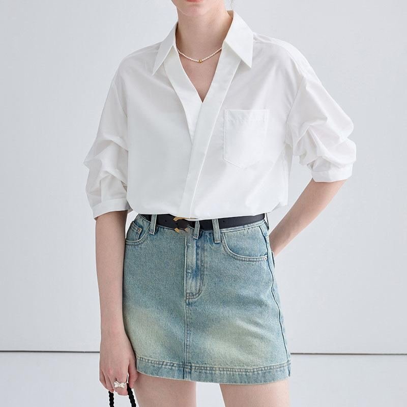Woman in a flowy chiffon blouse with a light-wash denim mini skirt