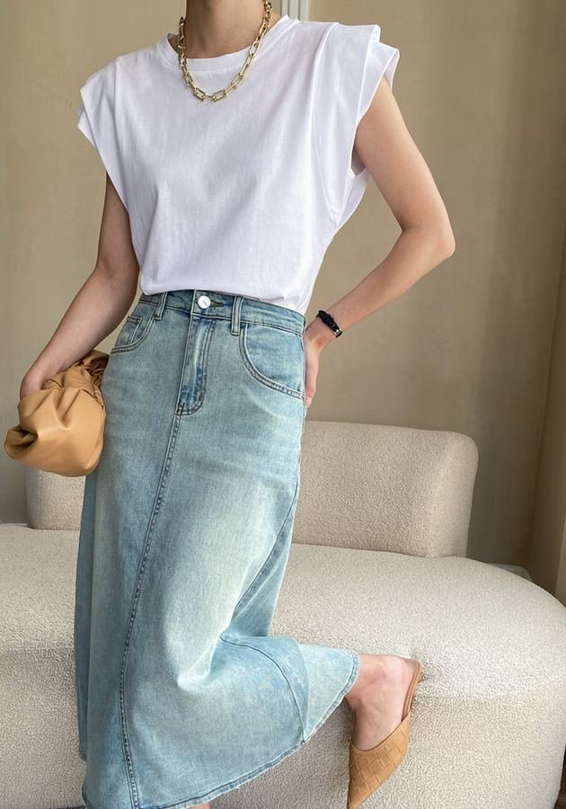 Woman in a white denim midi skirt with gold jewelry