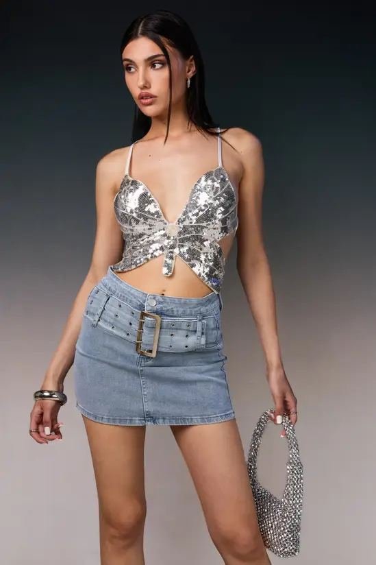 Woman in a sequined top with a denim mini skirt