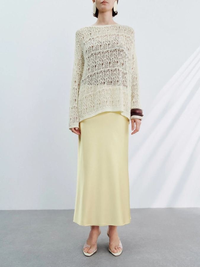 Woman in a butter-yellow slip skirt with cream knit top