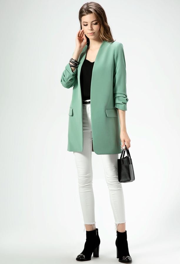 Woman wearing a mint blazer with white jeans