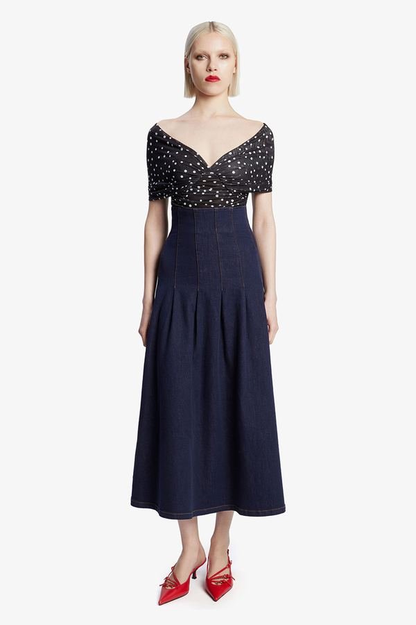 Woman in a polka-dot wrap top and denim midi skirt