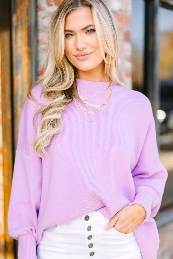 Woman in a lavender sweater and white jeans