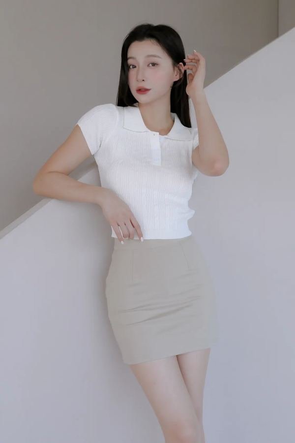 Woman wearing a terry polo with a knit mini skirt