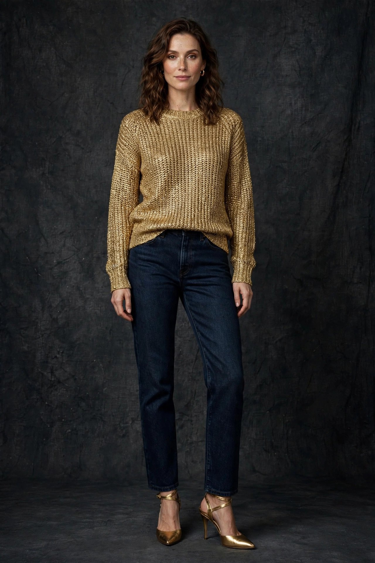 woman in gold metallic knit top with dark rinse jeans