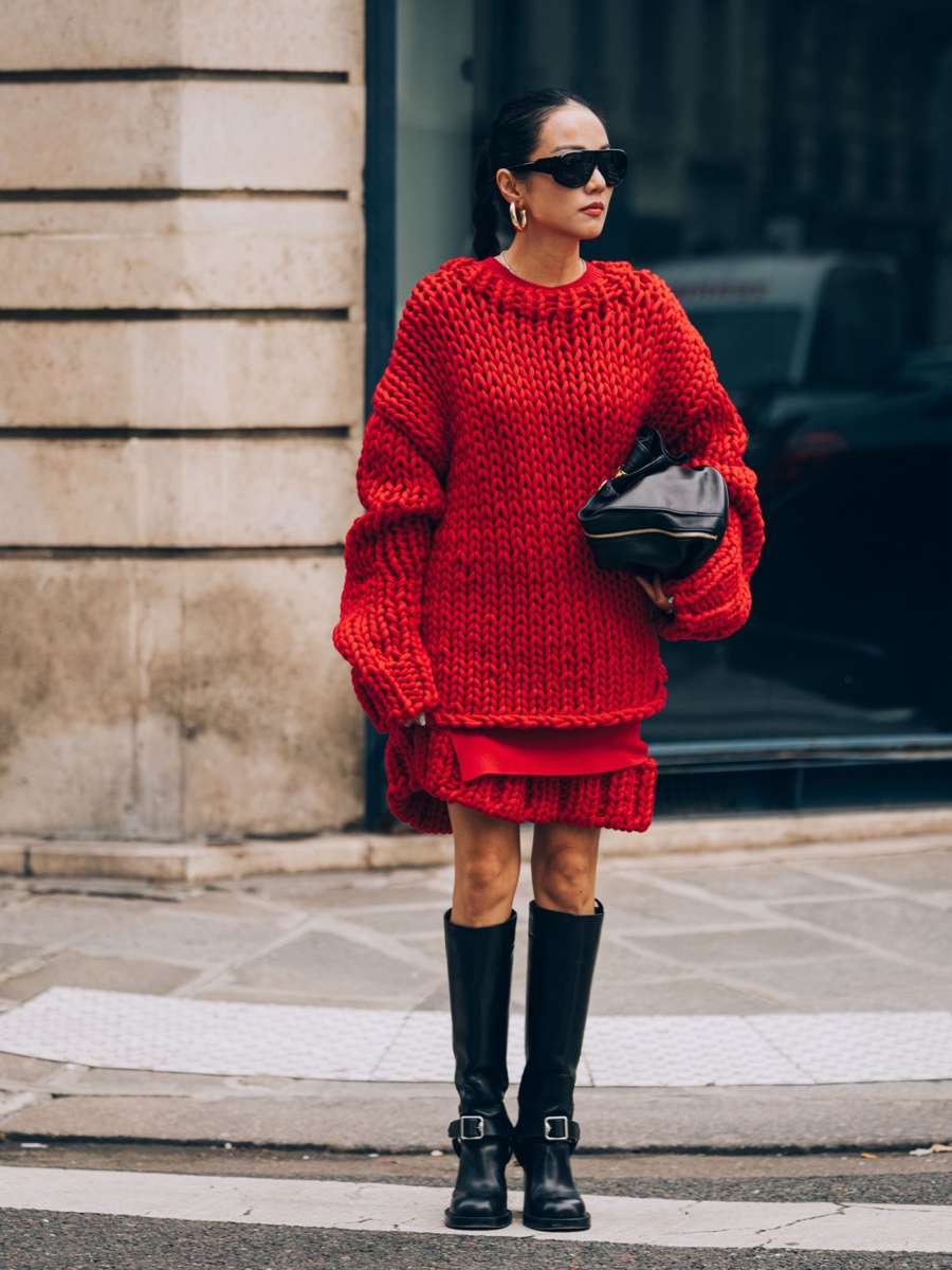woman in red sweater dress with black over-the-knee boots at a Christmas market