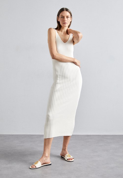 Woman wearing a knit midi dress with flat sandals
