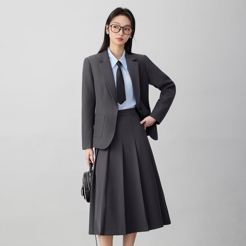 Woman wearing a dove gray pleated skirt suit